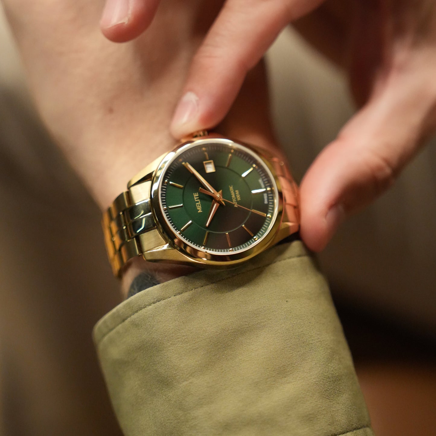MELITE PARFUMSH Men's gold PVD plated stainless steel automatic watch with emerald green sunburst dial and gold markers.