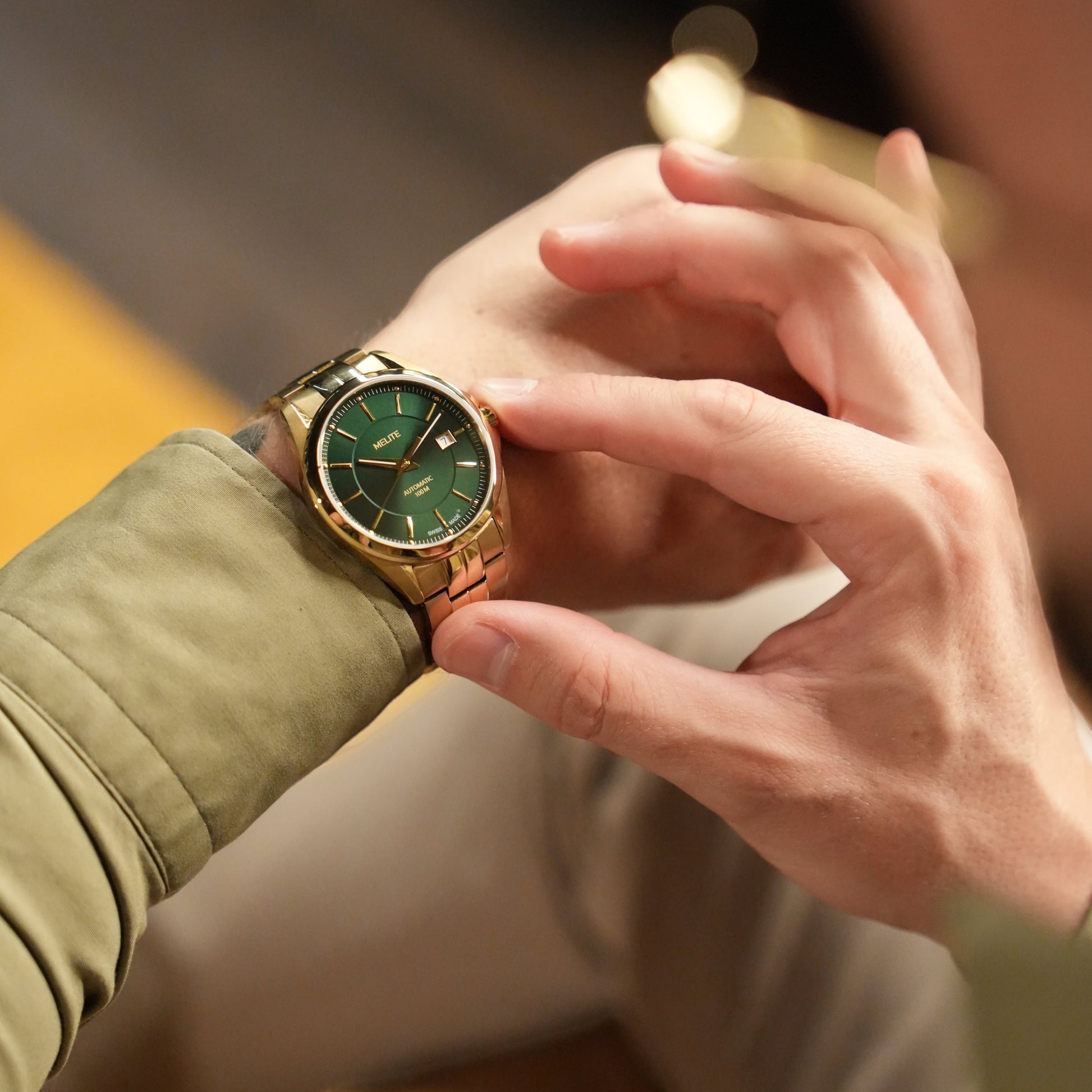MELITE PARFUMSH Men's gold PVD plated stainless steel watch with emerald green sunburst dial and gold markers.